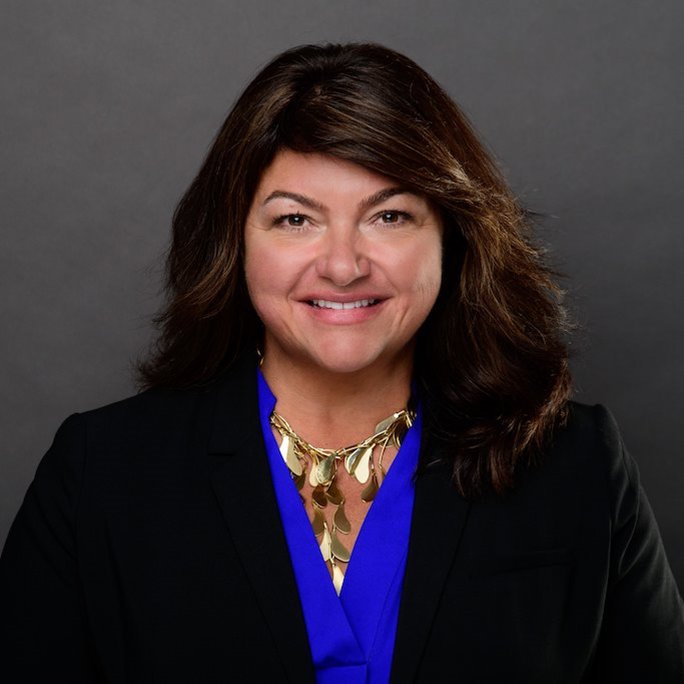 Headshot of Kathy Koshgarian wearing a royal blue top and black blazer.