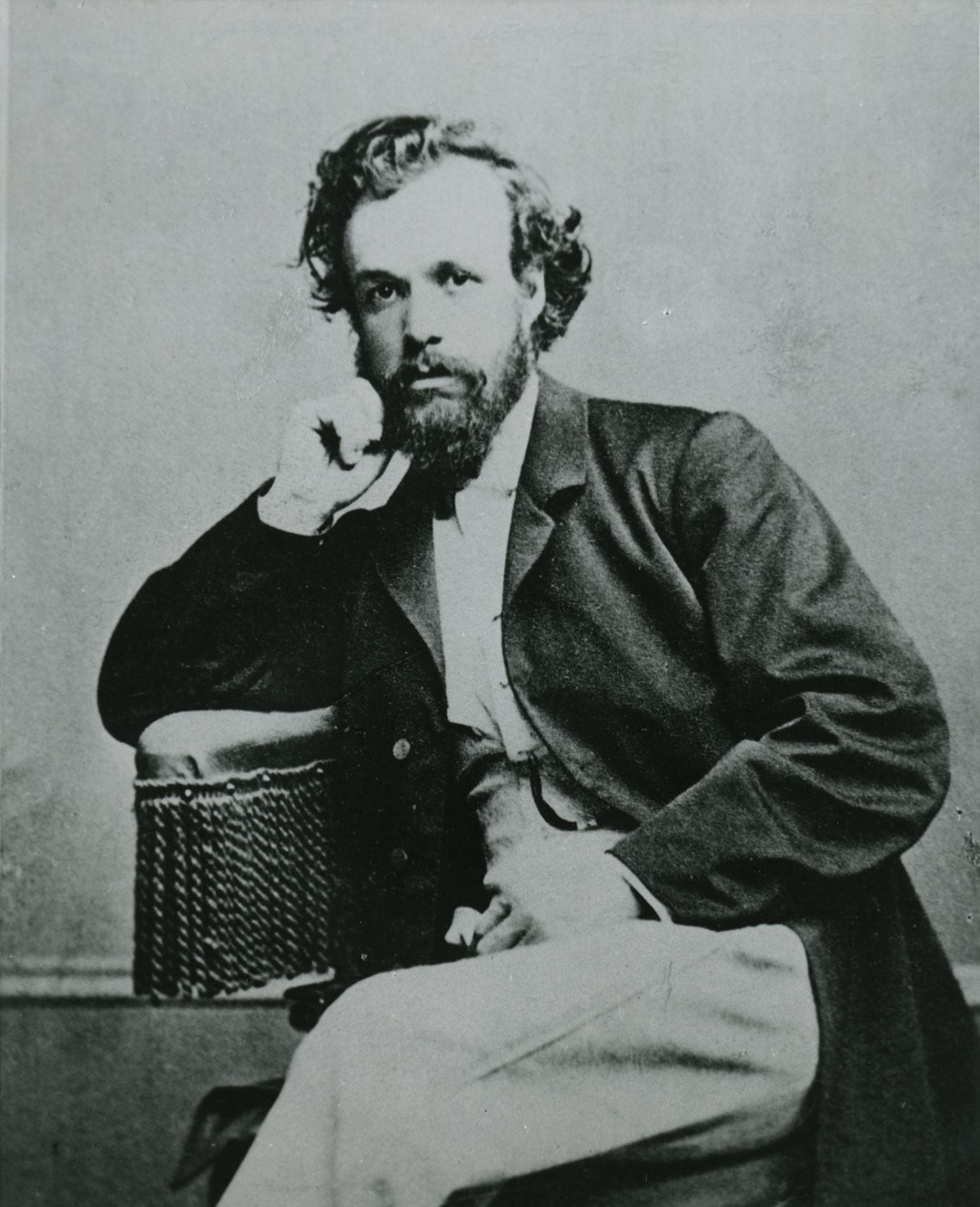 Black and white vintage portrait of German immigrant Friedrich W. Dohmen, a bearded man in a suit sitting with his head resting on his hand, gazing directly at the camera.