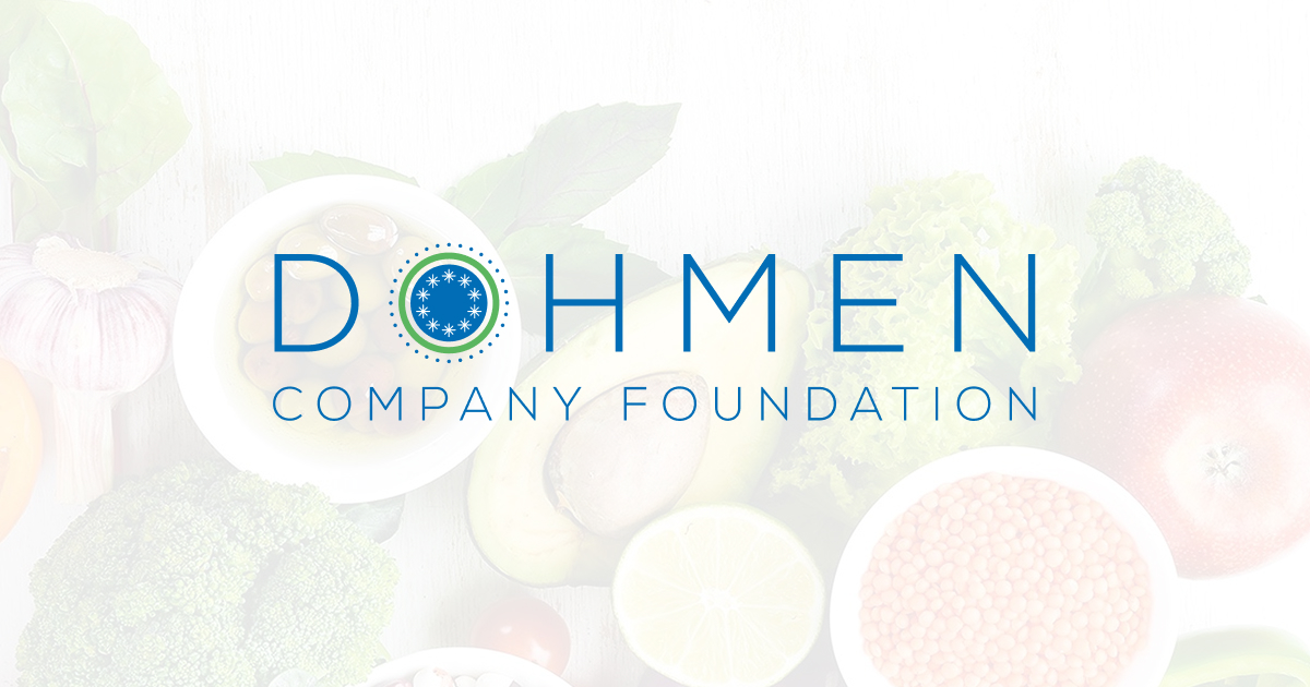 Dohmen Company Foundation logo with a circular star emblem in the letter ‘O’ and fresh fruits and vegetables in the background.