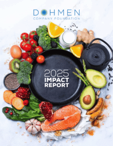 Colorful assortment of fresh vegetables and legumes including avocado, lime, broccoli, olives, garlic, and beans arranged on a white and grey marble surface. A banner across the middle reads ‘2025 Impact Report.’